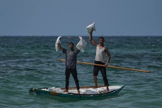 Palestinians collect aid that landed in the Mediterranean Sea after being airdropped over central Gaza, at the shore of Zawaida, Gaza Strip